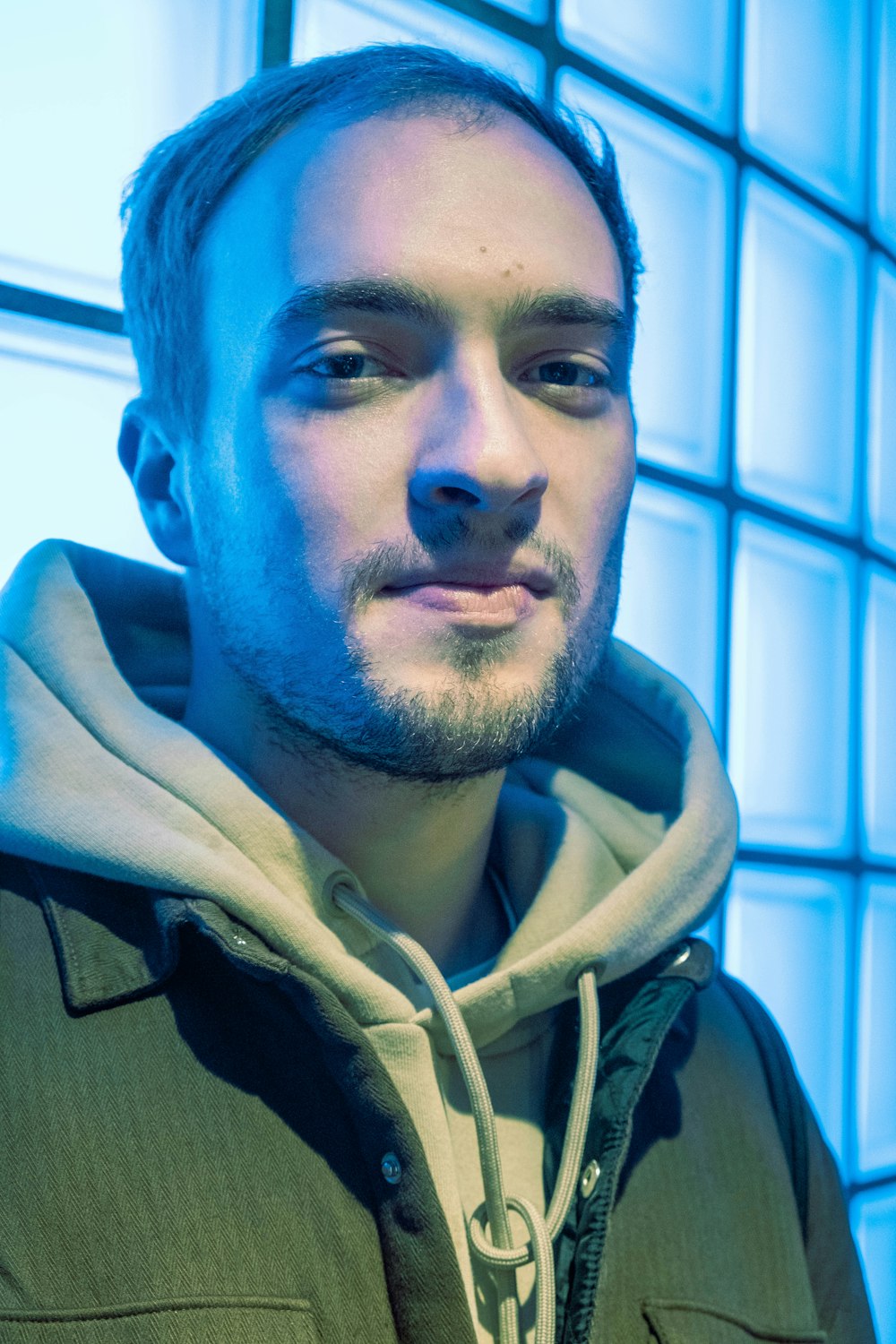 a man in a hoodie looking at the camera