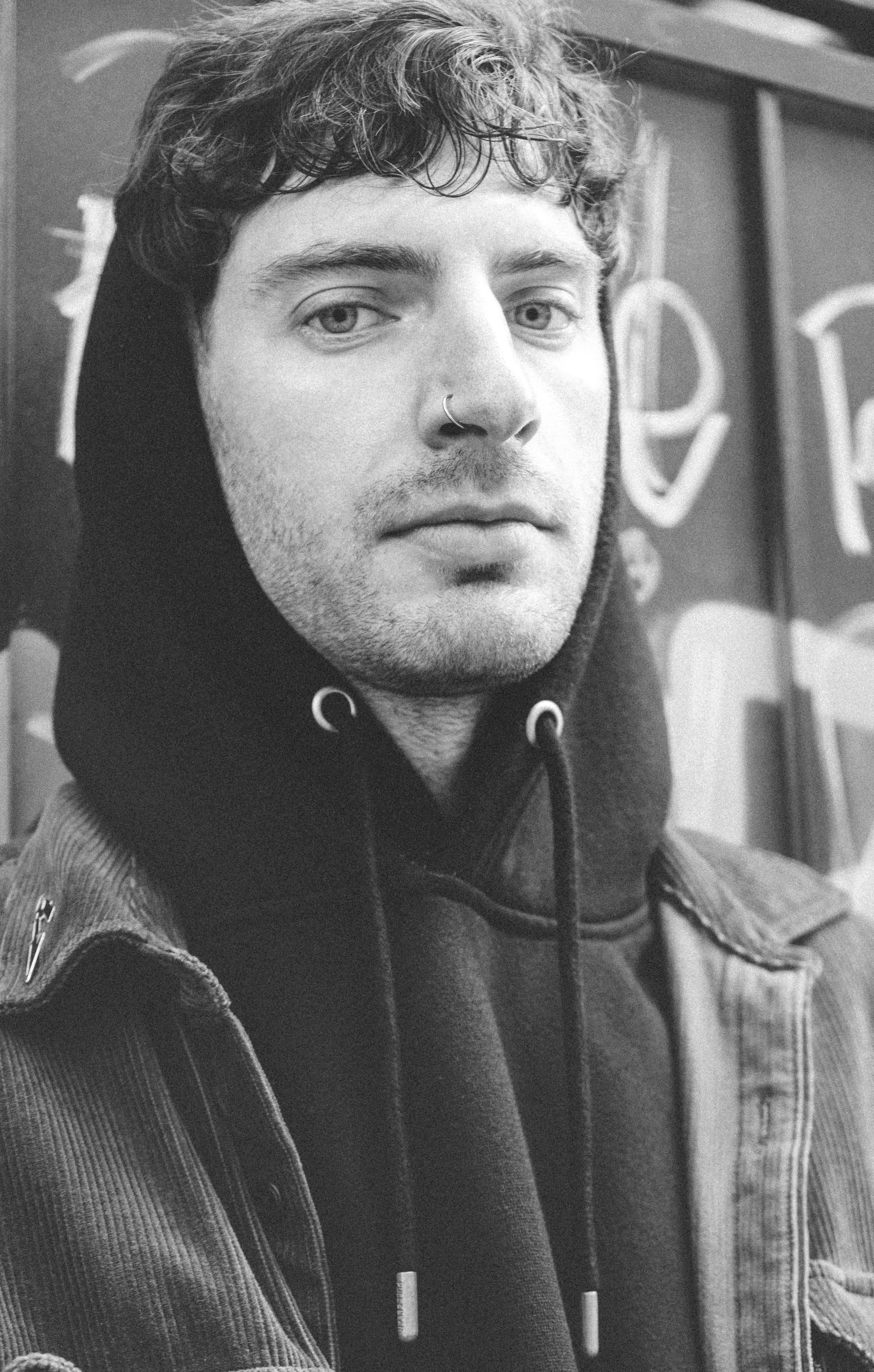 Ein Schwarz-Weiß-Foto eines Mannes im Kapuzenpulli