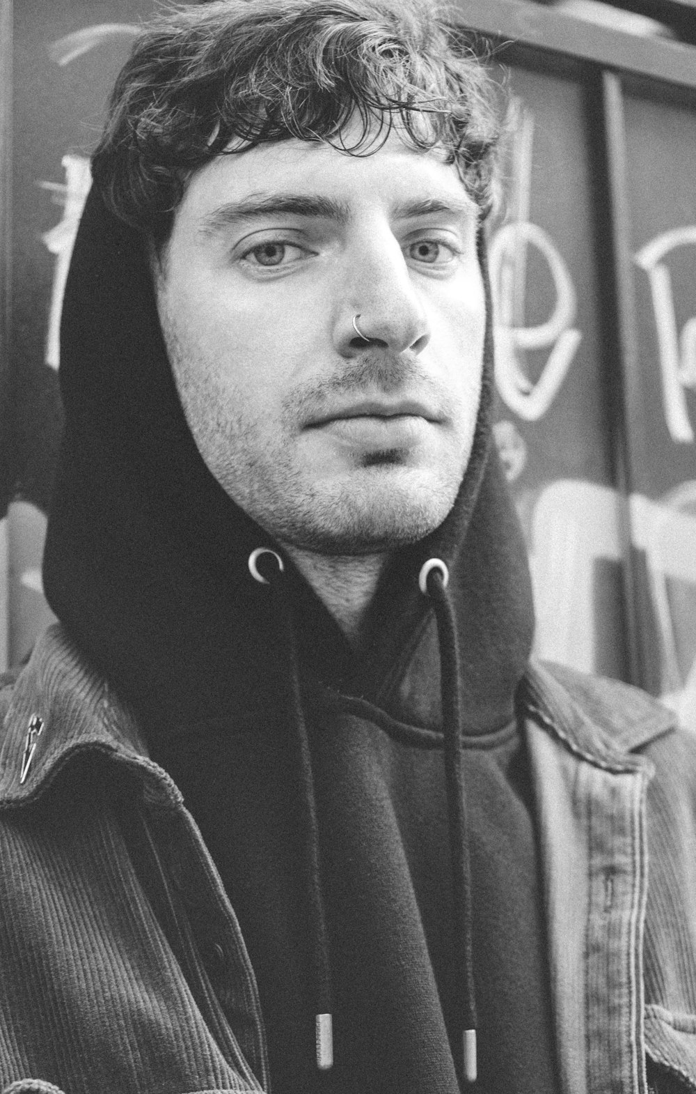 a black and white photo of a man wearing a hoodie