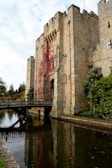 a bridge crossing a river in front of a castle