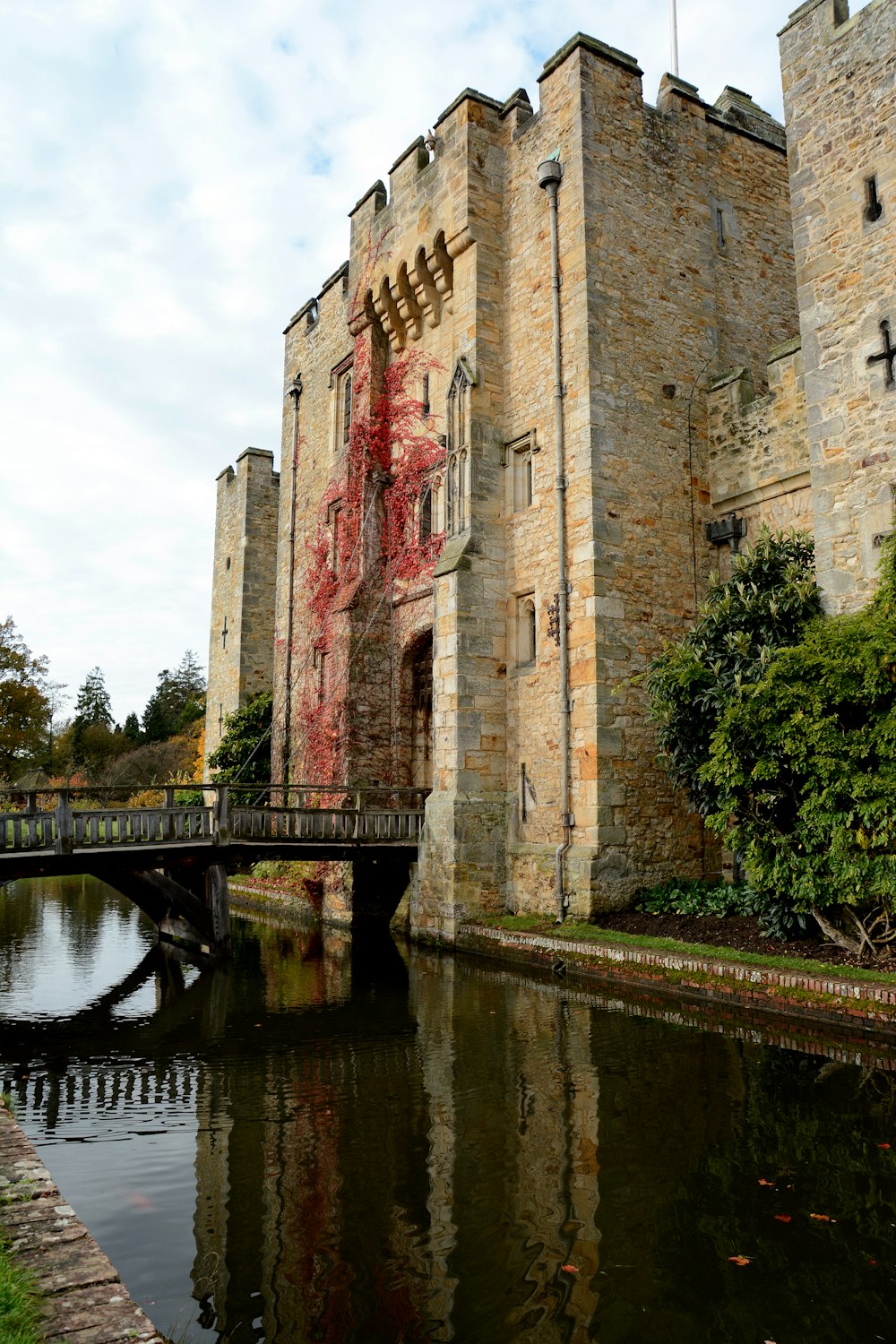 a bridge crossing a river in front of a castle