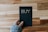 a person holding a black book with the word buy written on it
