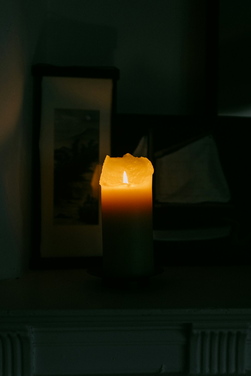 a lit candle sitting on top of a mantle