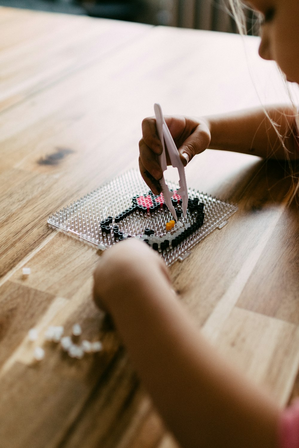 a little girl cutting a piece of lego with a pair of scissors