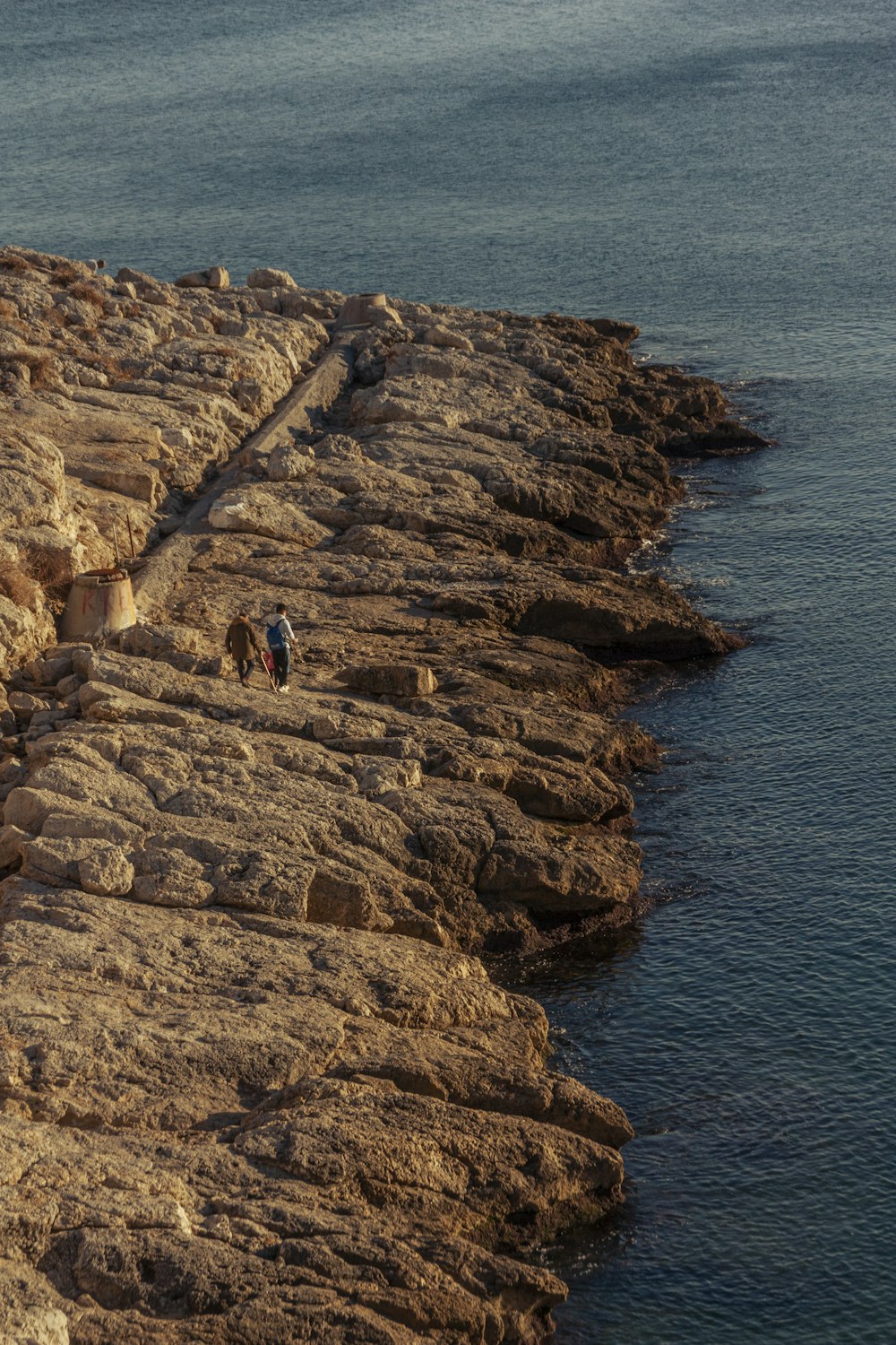 a group of people walking along the edge of a cliff