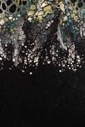 Abstract art depicting a multitude of cell-like shapes in varying sizes, resembling a biological or chemical pattern, with colors transitioning from yellow and green at the top to blue and black at the bottom.