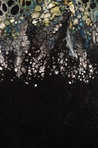 Abstract art depicting a multitude of cell-like shapes in varying sizes, resembling a biological or chemical pattern, with colors transitioning from yellow and green at the top to blue and black at the bottom.