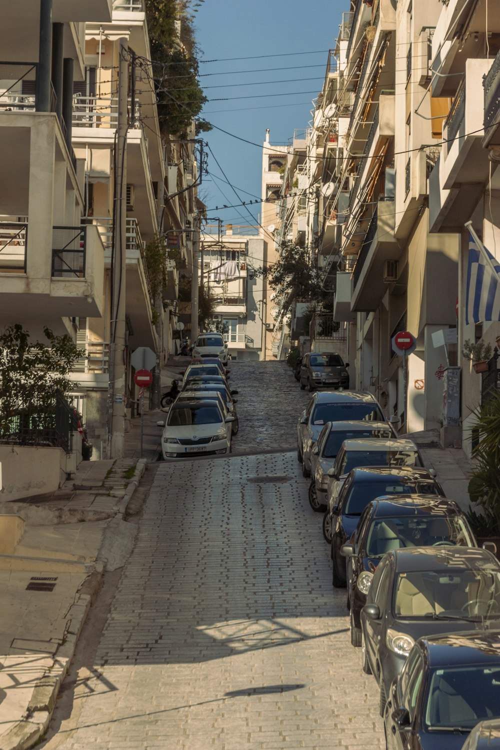 a street lined with parked cars next to tall buildings