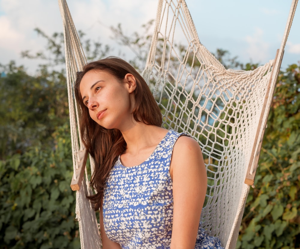 a woman sitting in a hammock in a field