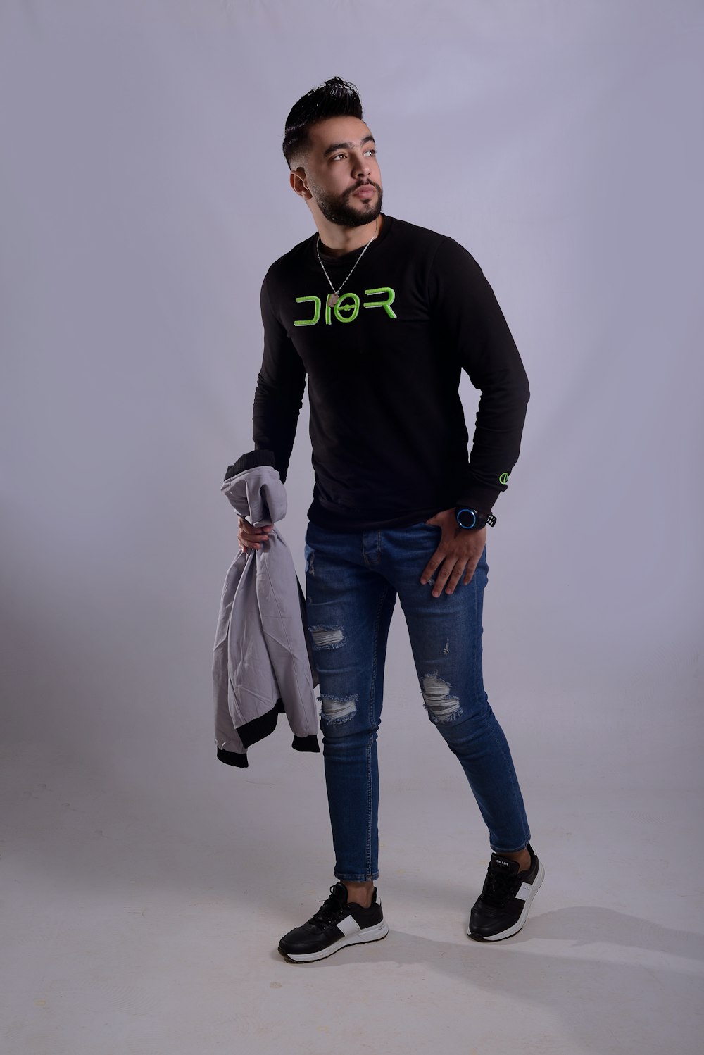 Un hombre con camisa negra y jeans posando para una foto