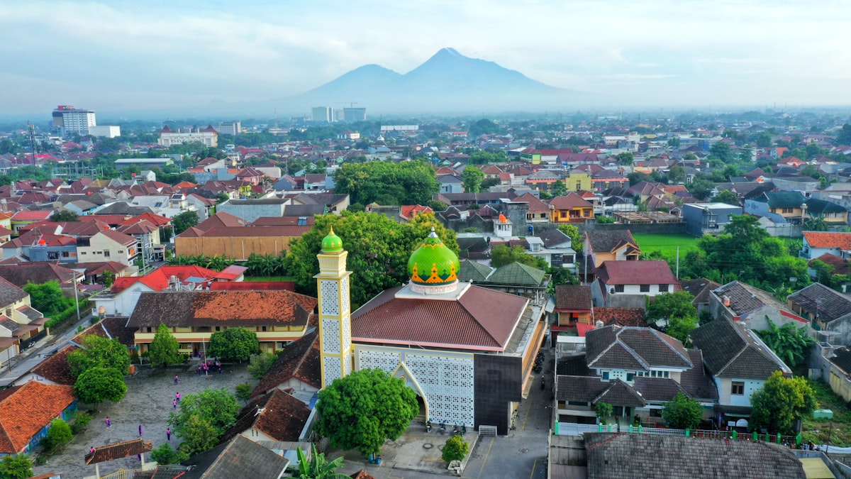 Kaliurang Yogyakarta — aerial view of Yogyakarta city with Mount Merapi and green mosque dome