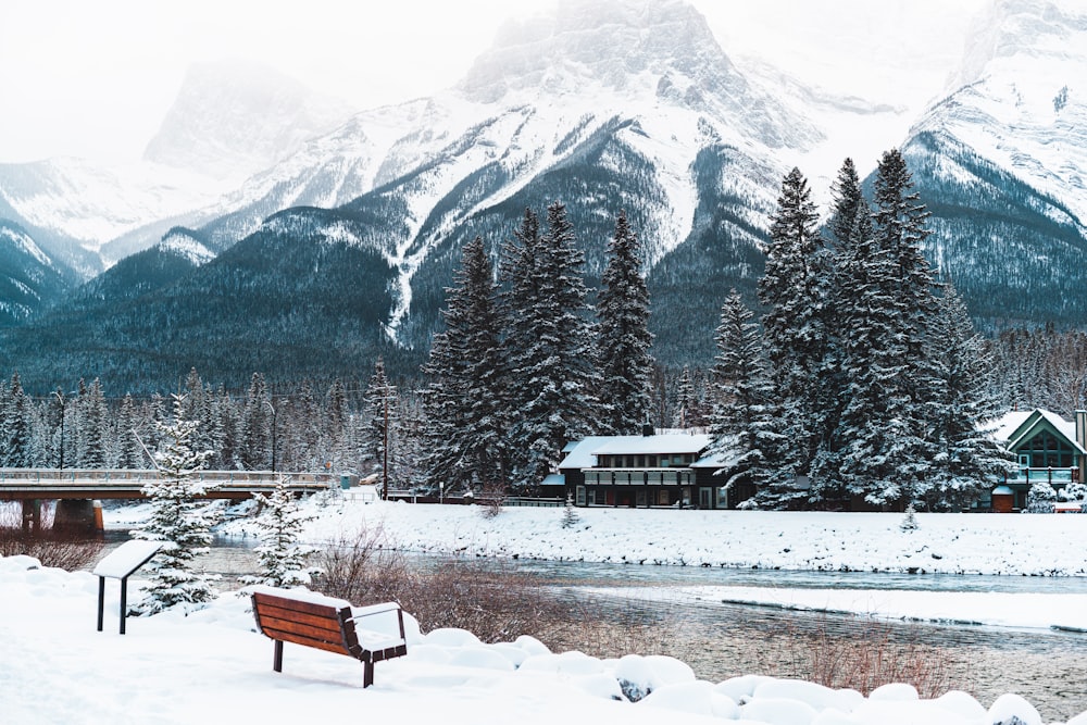 a wooden bench sitting on top of a snow covered field