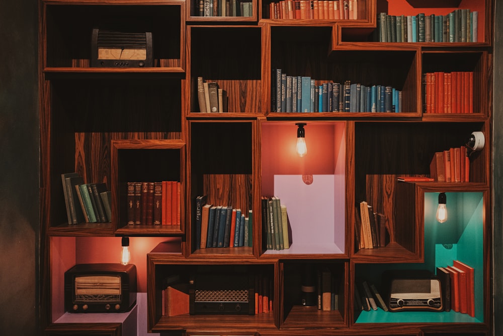 a bookshelf filled with lots of books next to a lamp