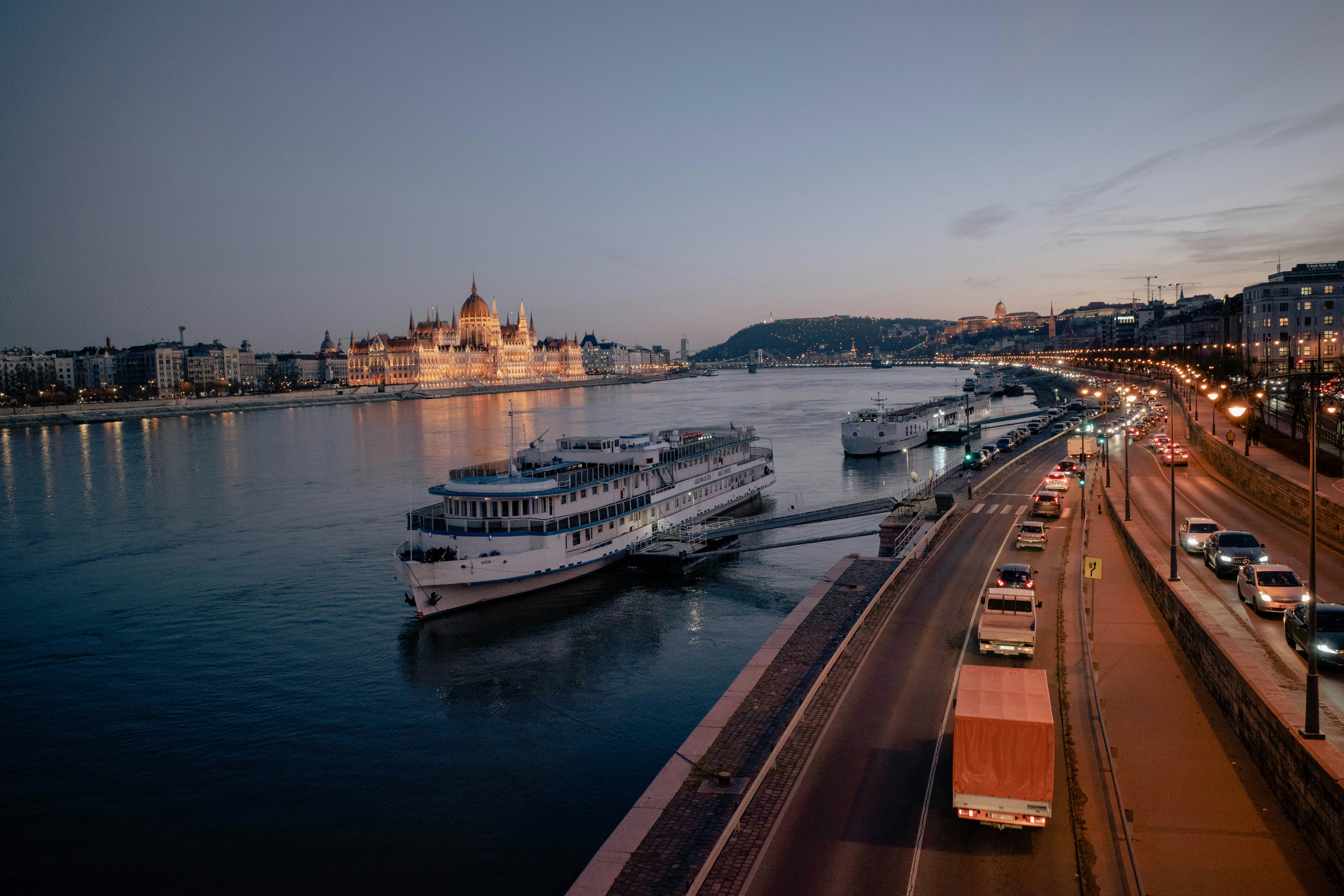 a river filled with lots of traffic next to a bridge