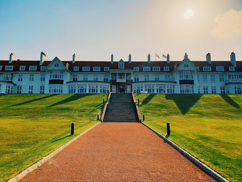 a large white building with a long walkway leading to it