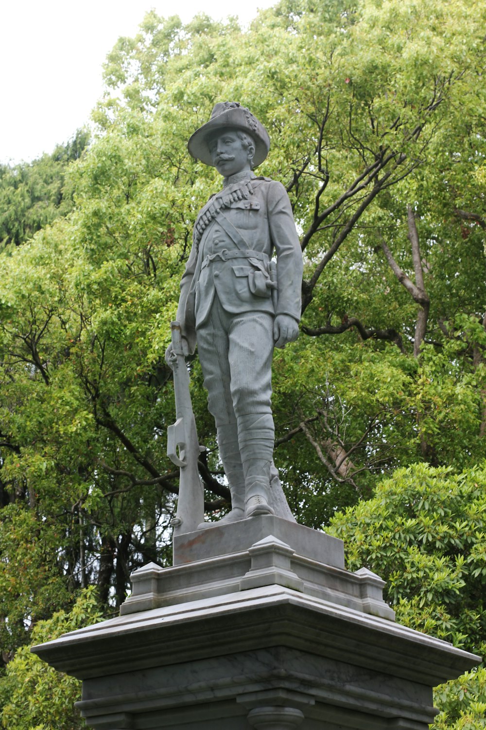 a statue of a man wearing a hat and holding a cane