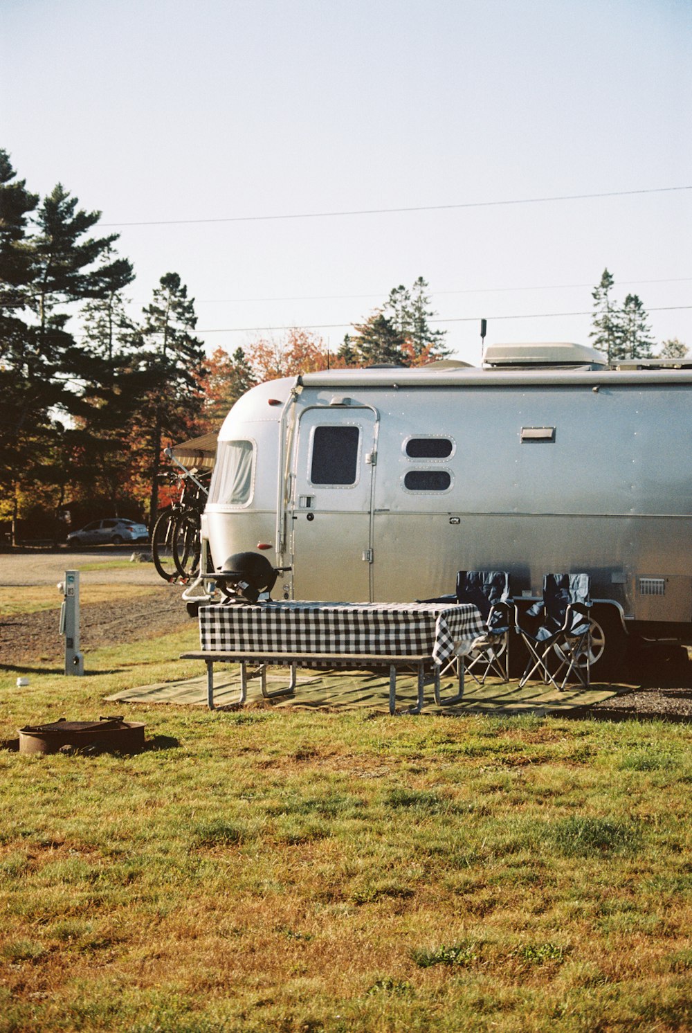 Un RV estacionado en un campo junto a una mesa de picnic