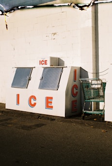 an ice cream stand with a shopping cart in front of it