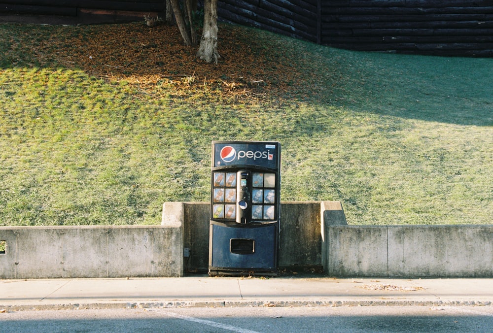 a public phone booth sitting on the side of a road