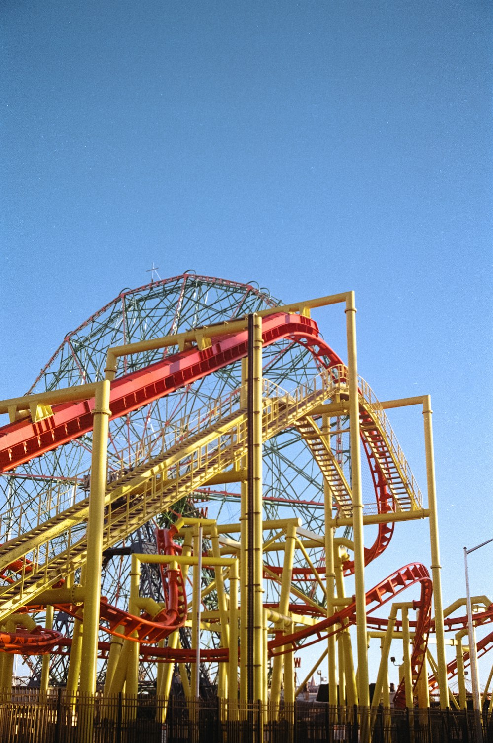 a red and yellow roller coaster at a theme park