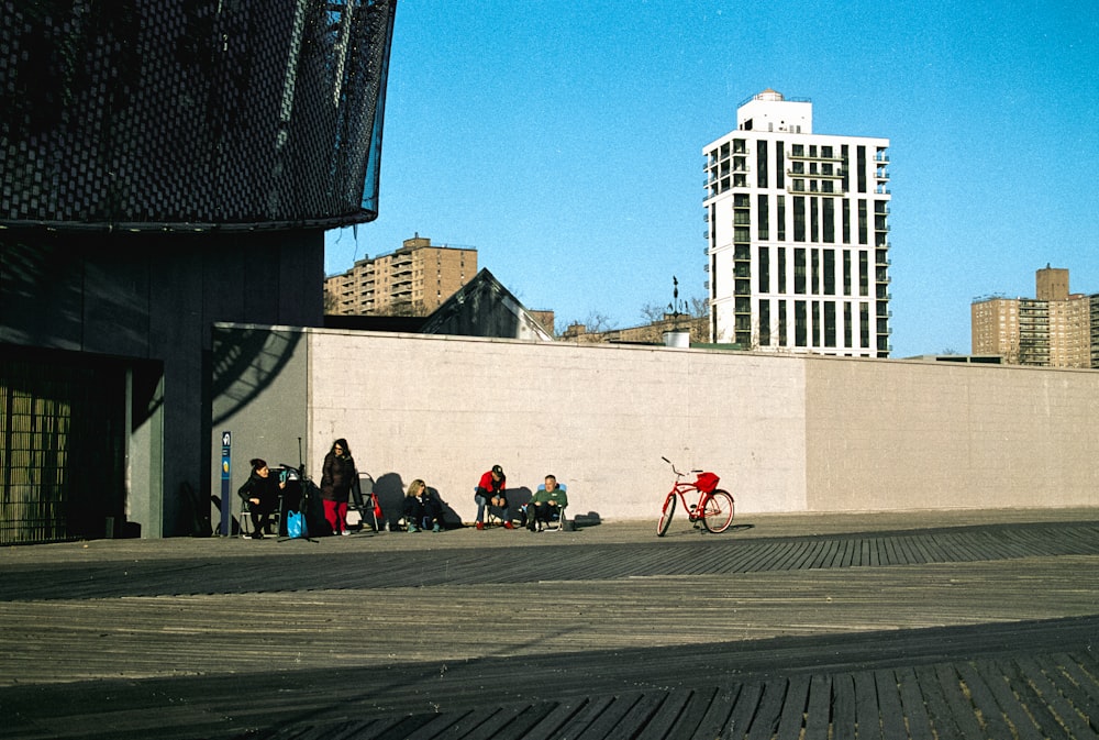 a group of people sitting on the side of a building