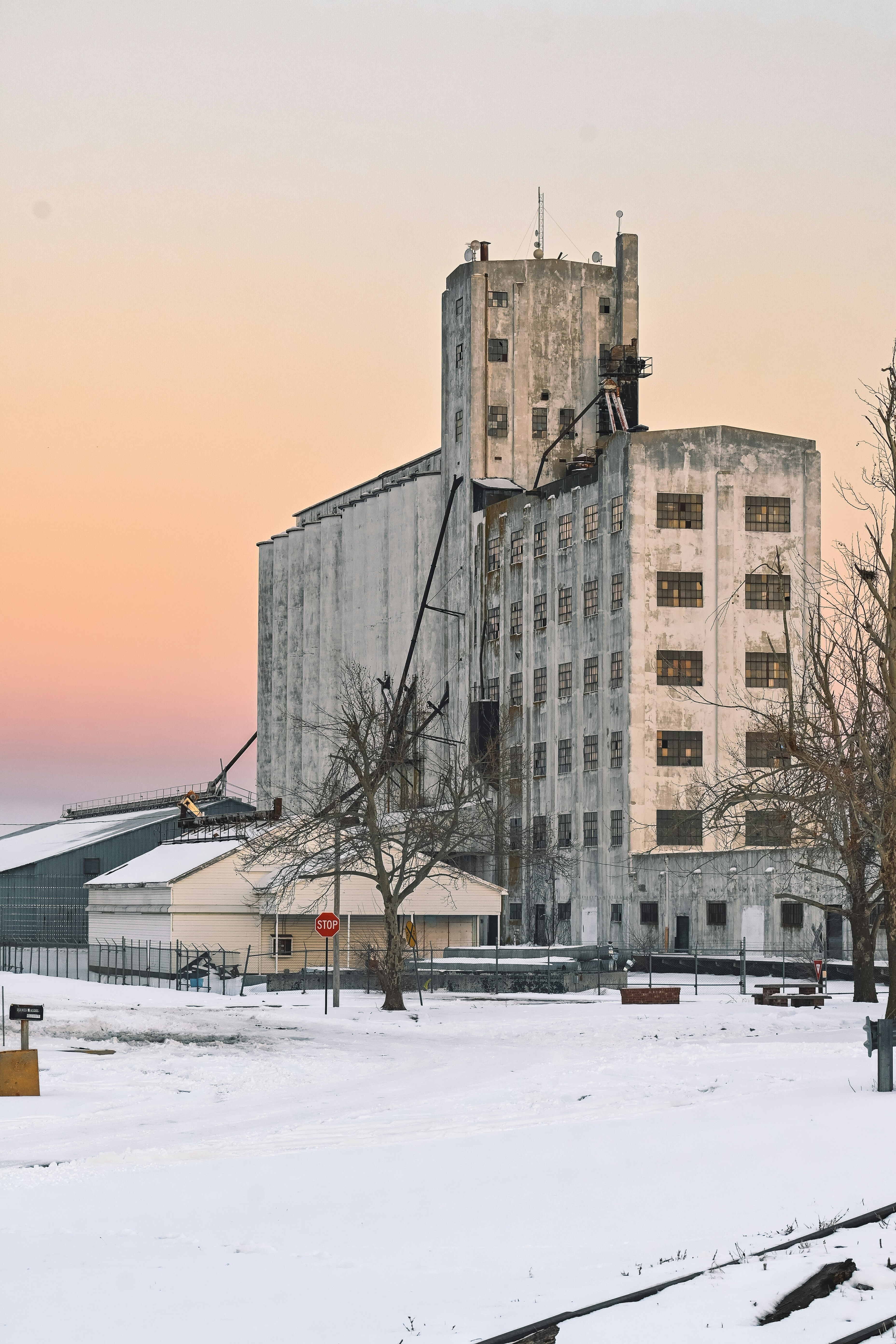 a very tall building sitting next to a snow covered field