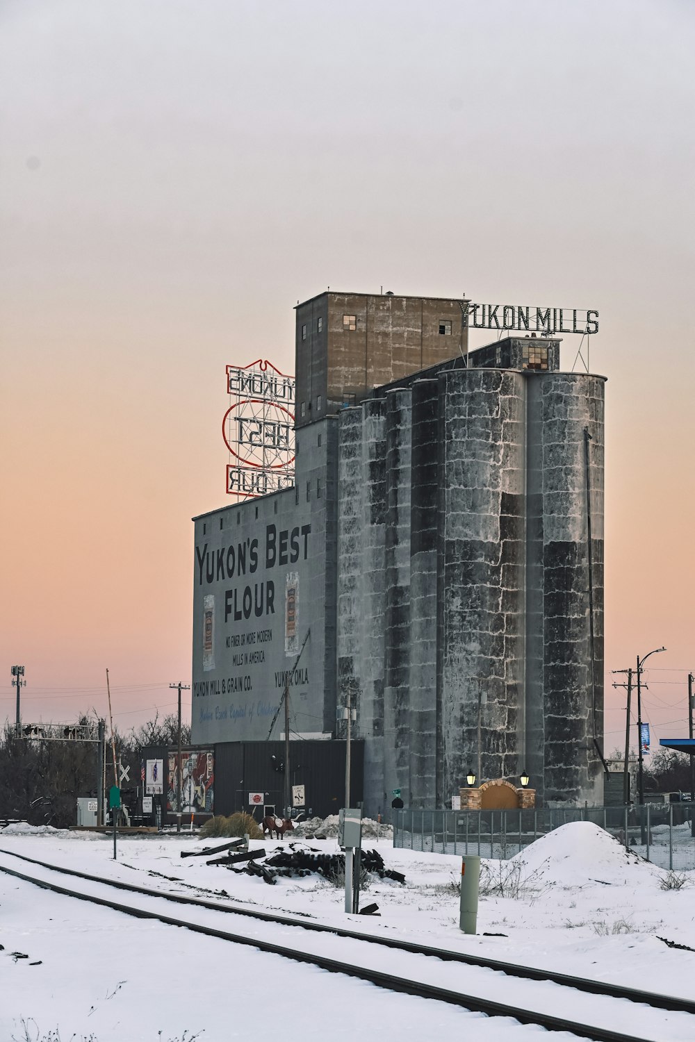 a train track runs past a building with a sign on it