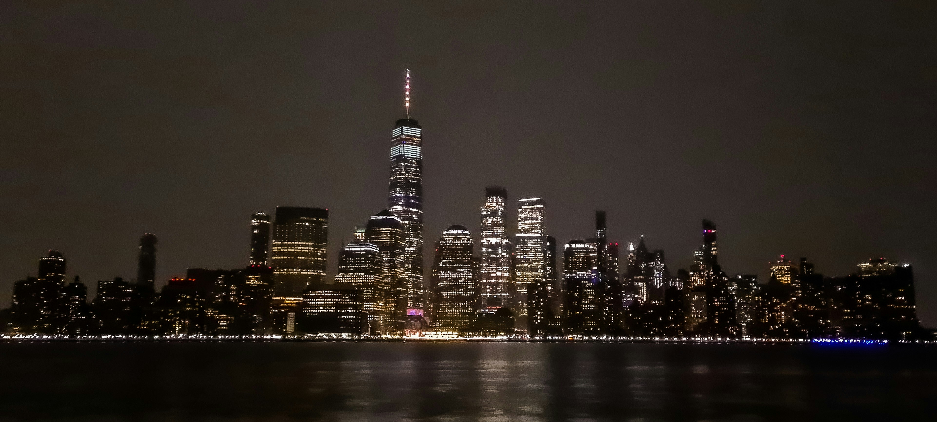 Una vista di una città di notte dall'altra parte dell'acqua