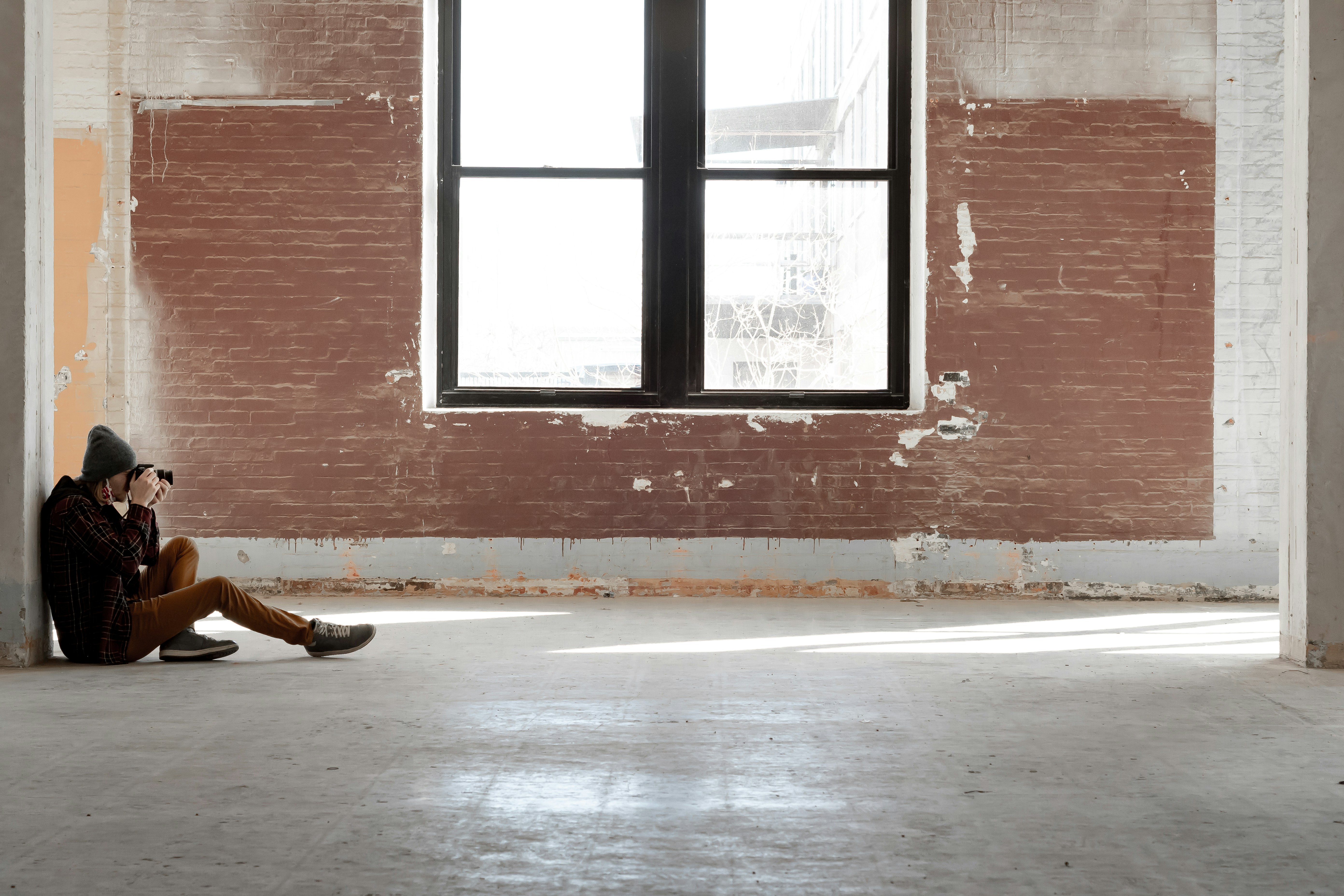 a person sitting on the floor in front of a window