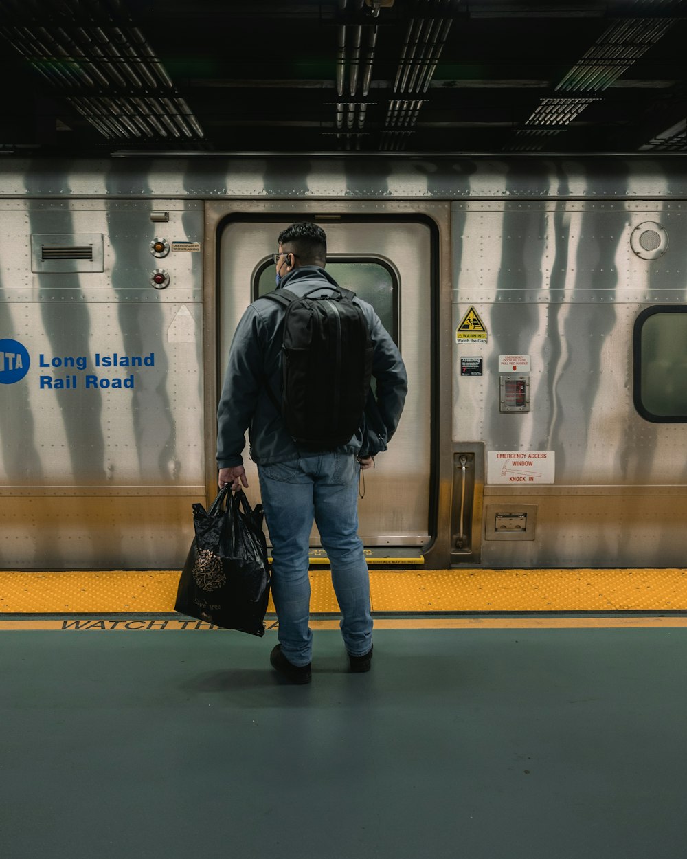 a man with a backpack is walking towards a train
