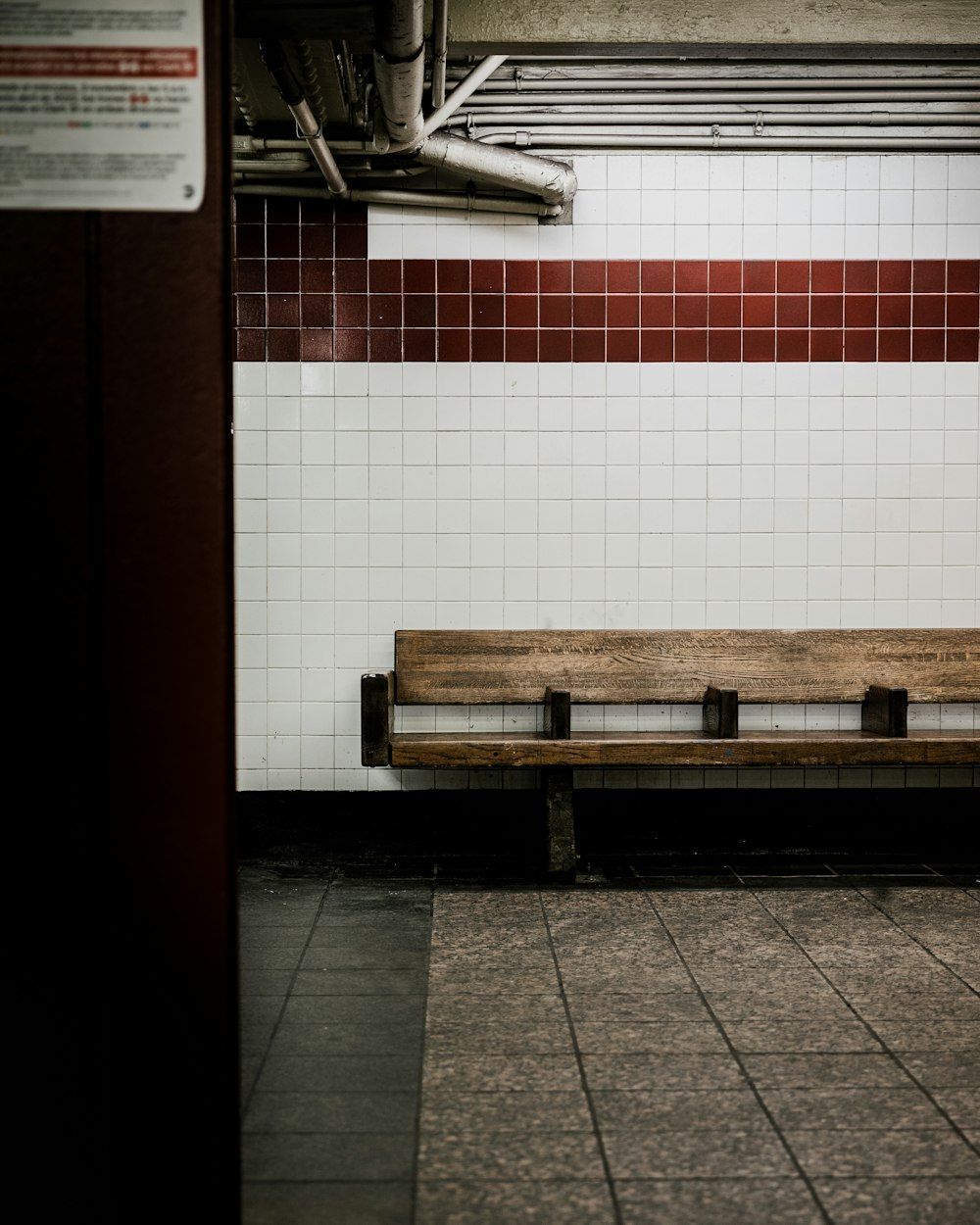 a wooden bench sitting in a subway station