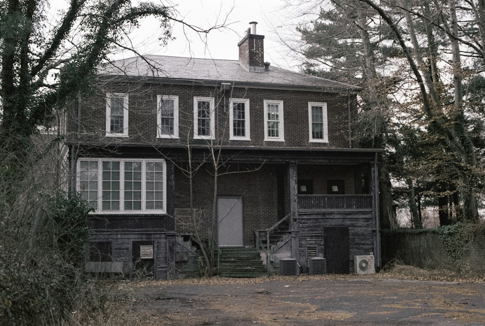 a black and white photo of a house in the woods