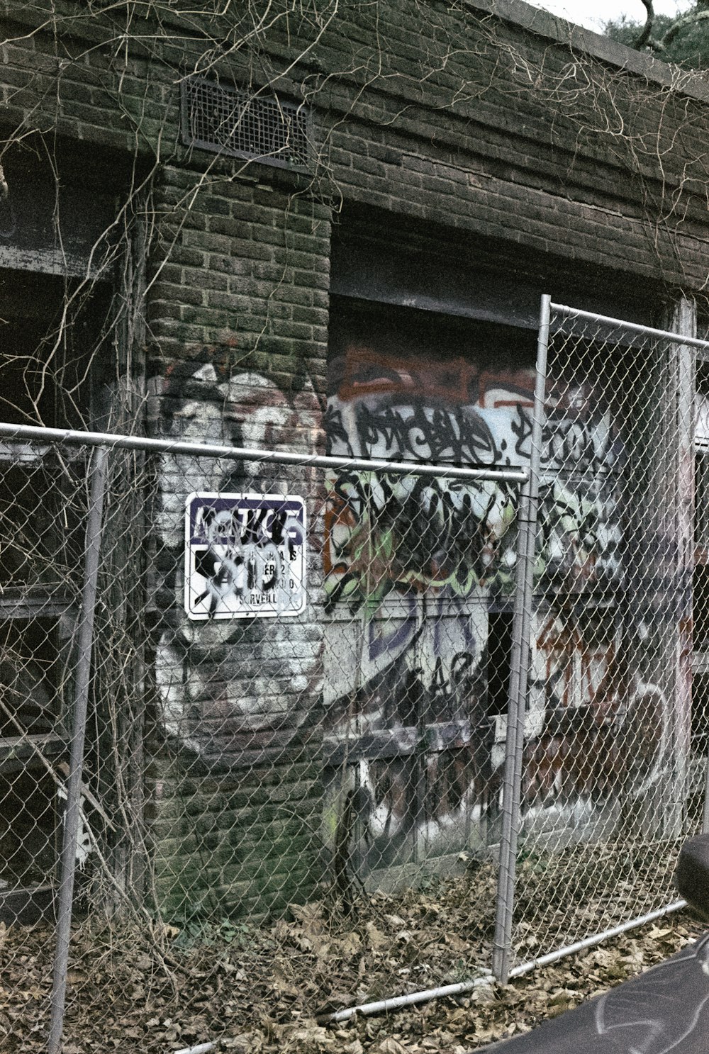 a graffiti covered building behind a chain link fence