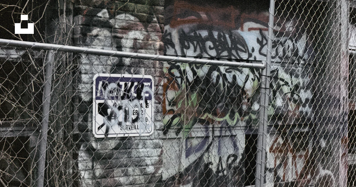 Chain Graffiti A graffiti covered building behind a chain link fence photo – Free ...