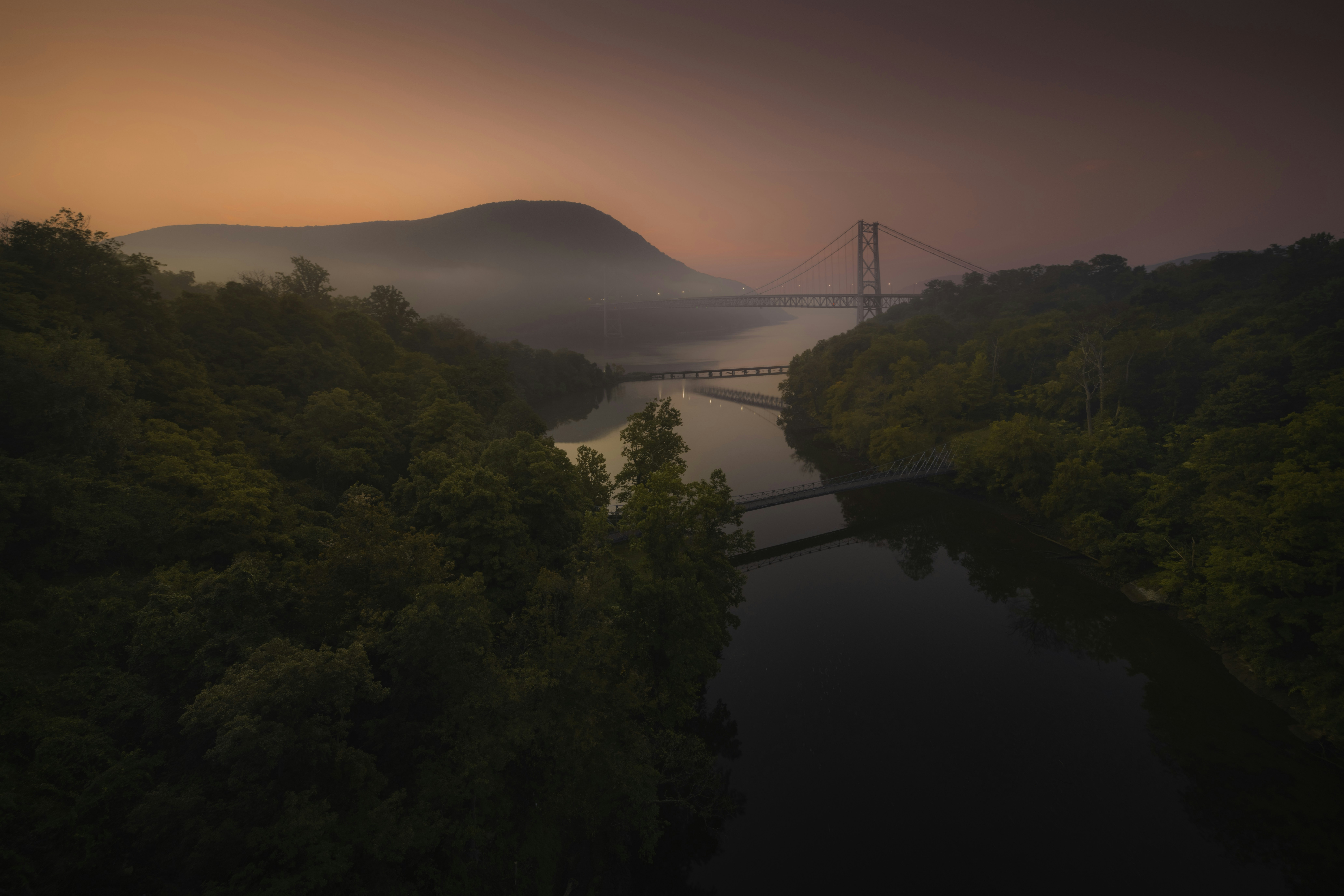木々に囲まれた川に架かる橋