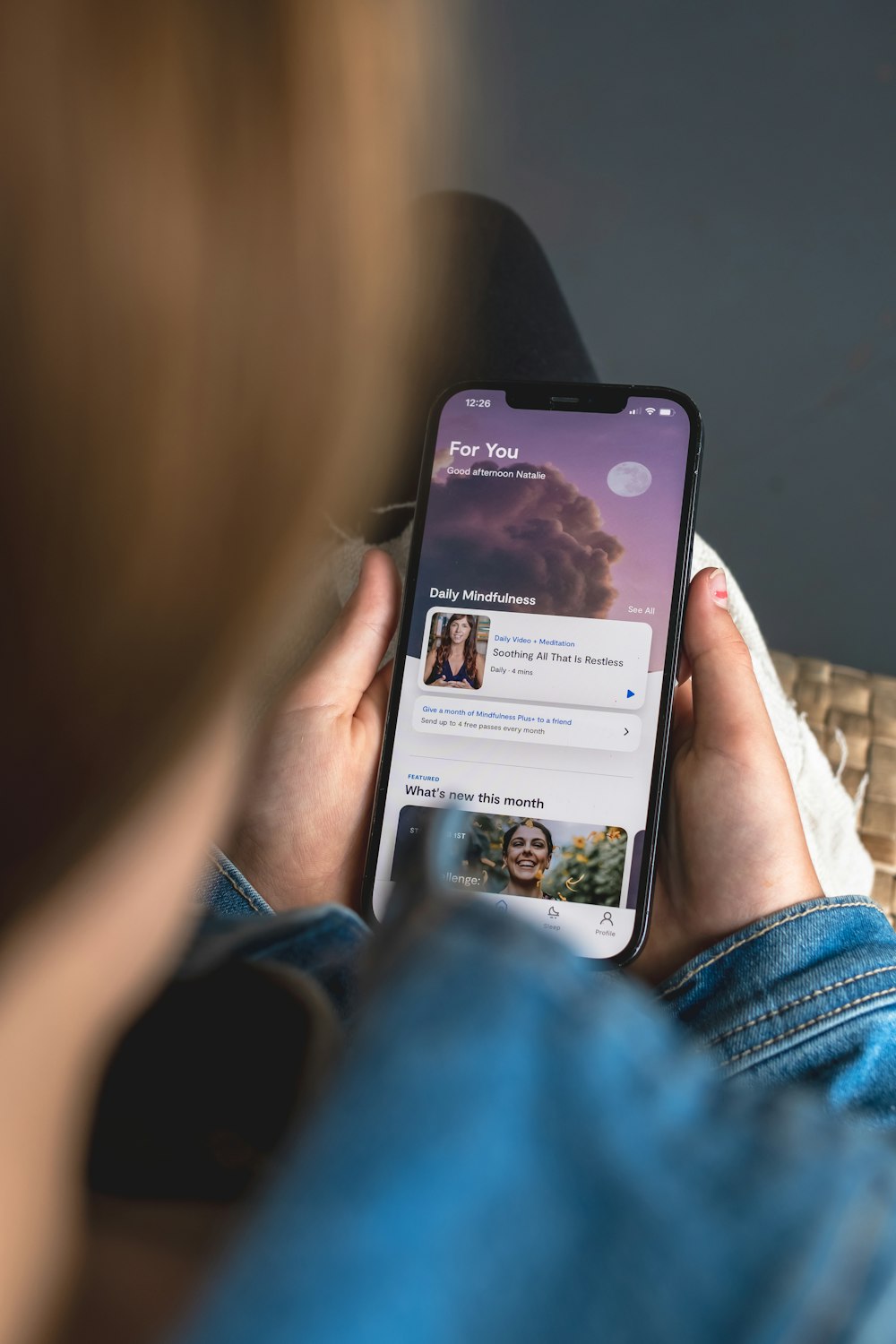 a woman holding a cell phone with a facebook page on it