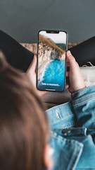 a person sitting on a couch holding a cell phone