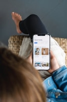 a person laying on a couch holding a cell phone