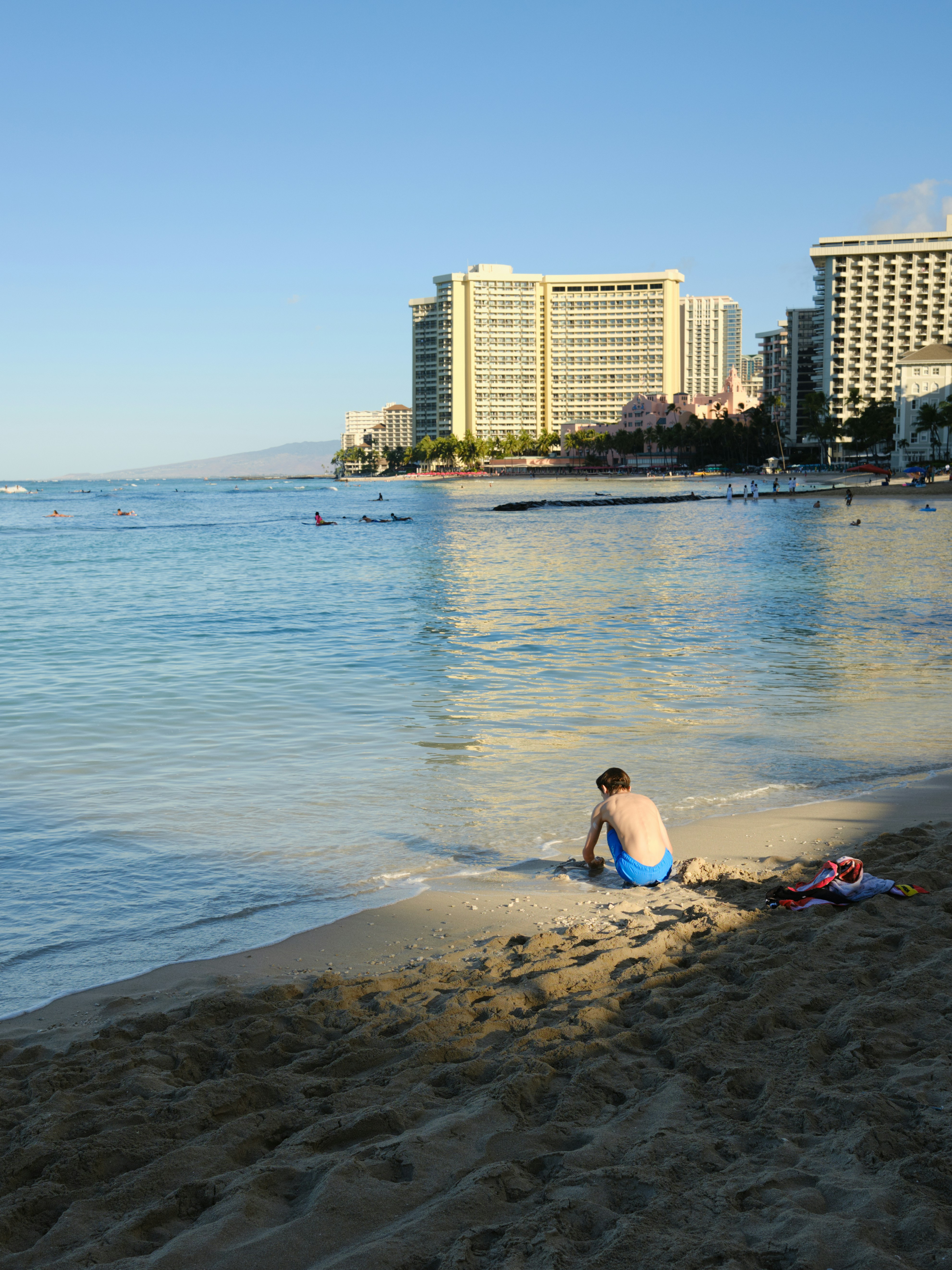 Ein Mann sitzt im Sand am Strand