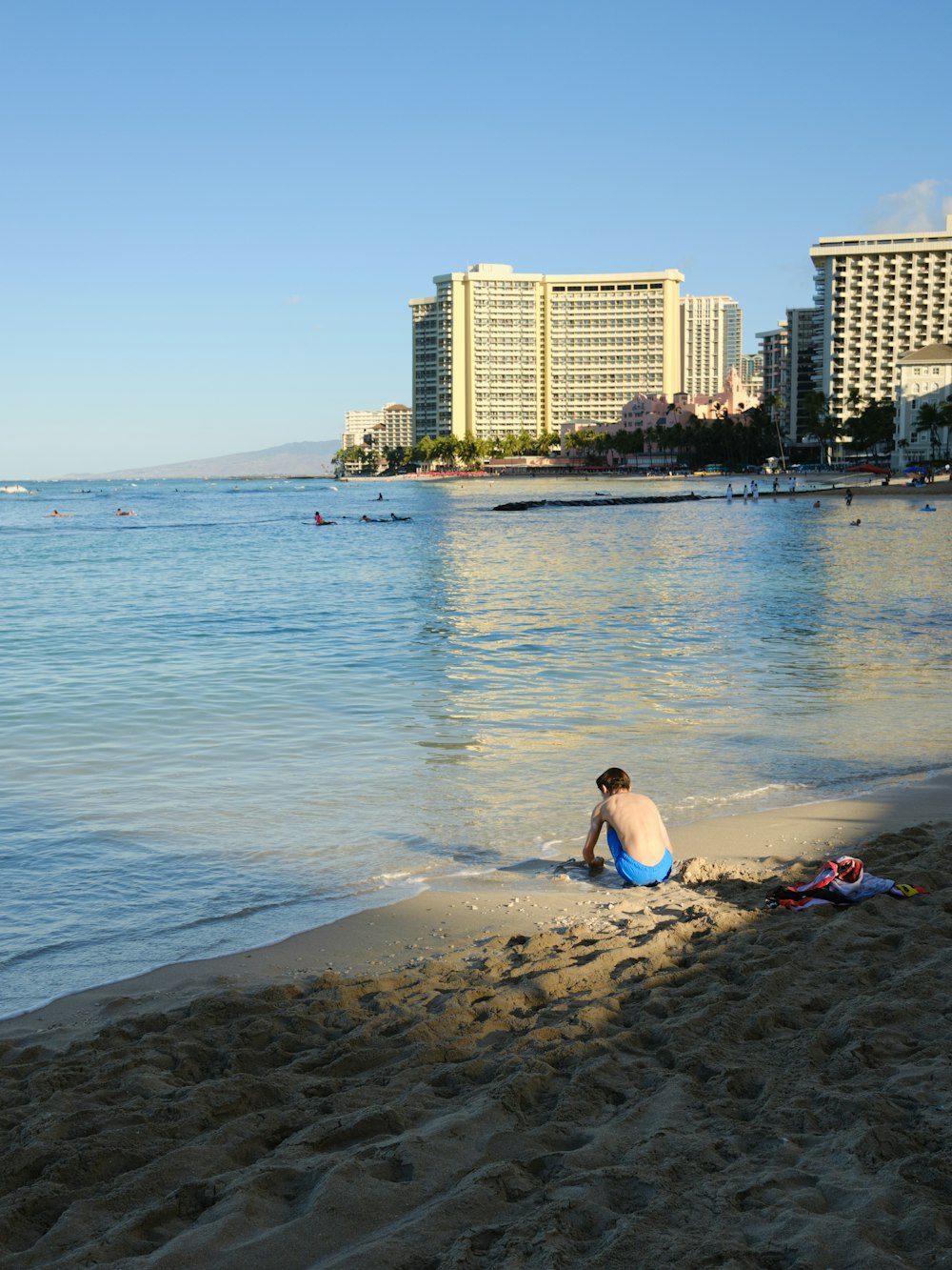 a man sitting in the sand on a beach