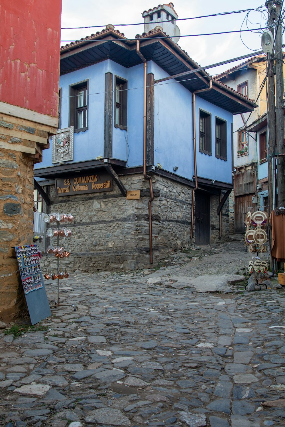 a cobblestone street with a blue building in the background