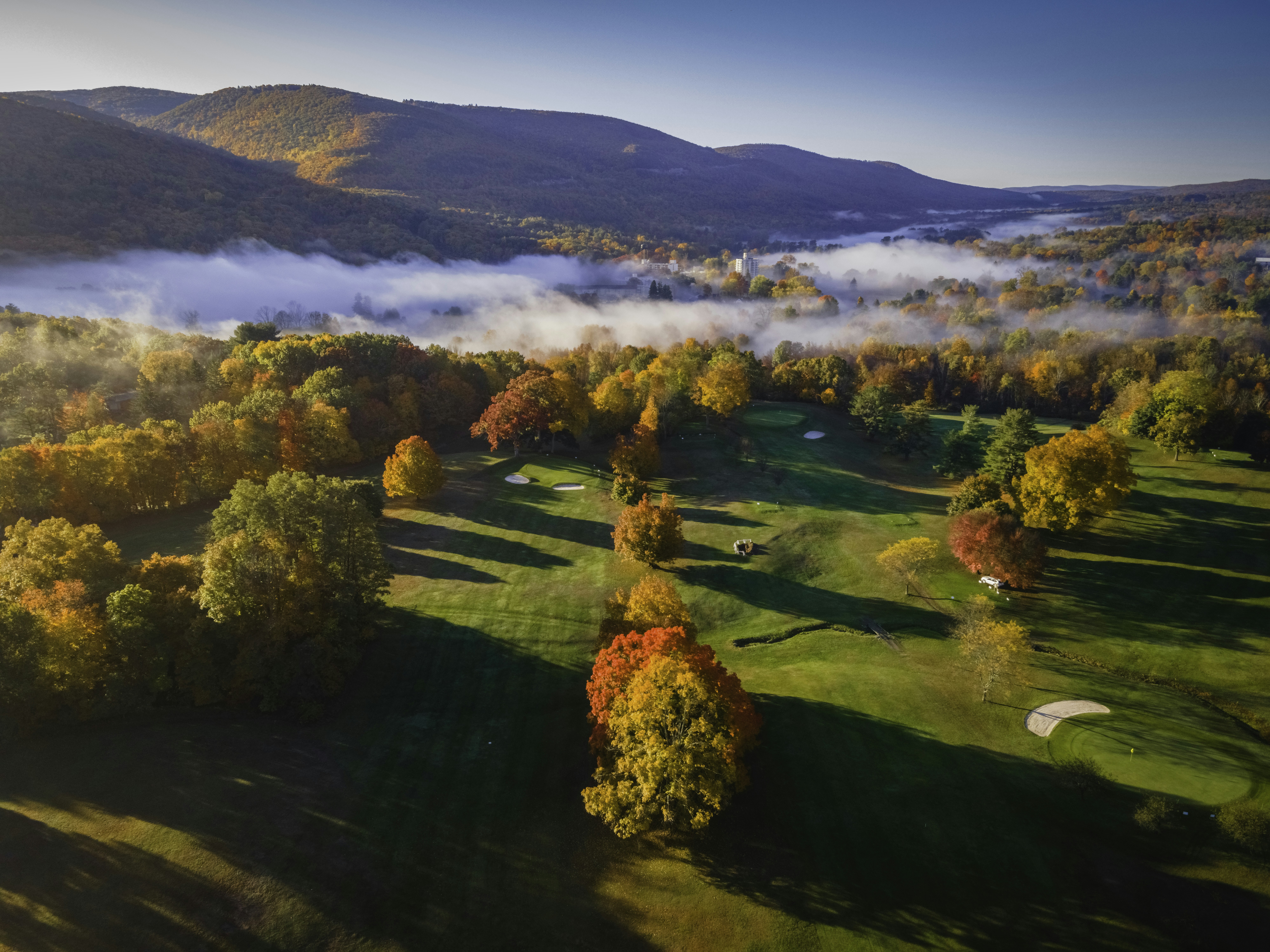 An aerial view of a golf course surrounded by trees photo Free Ny Image on Unsplash