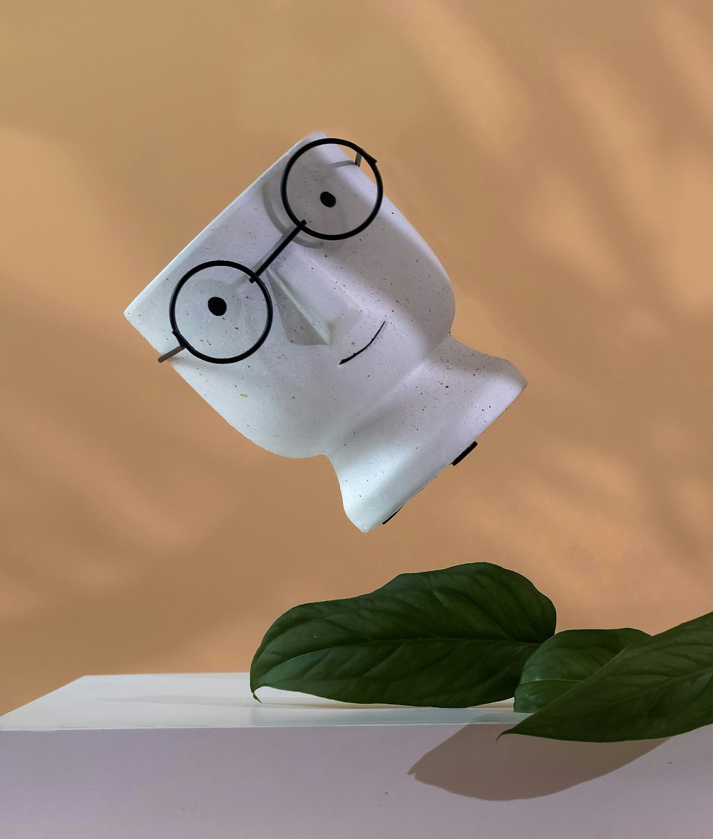 a coffee cup with a face and glasses on it
