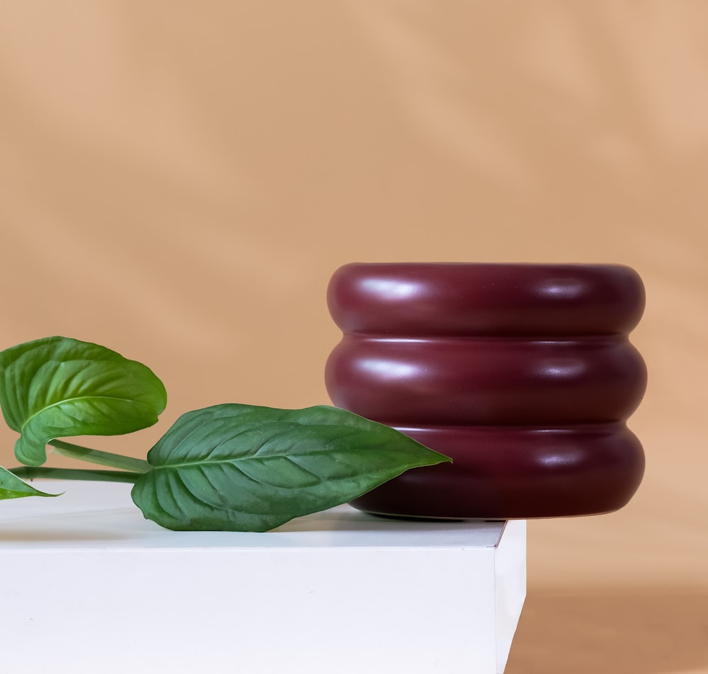 a red vase sitting on top of a white box