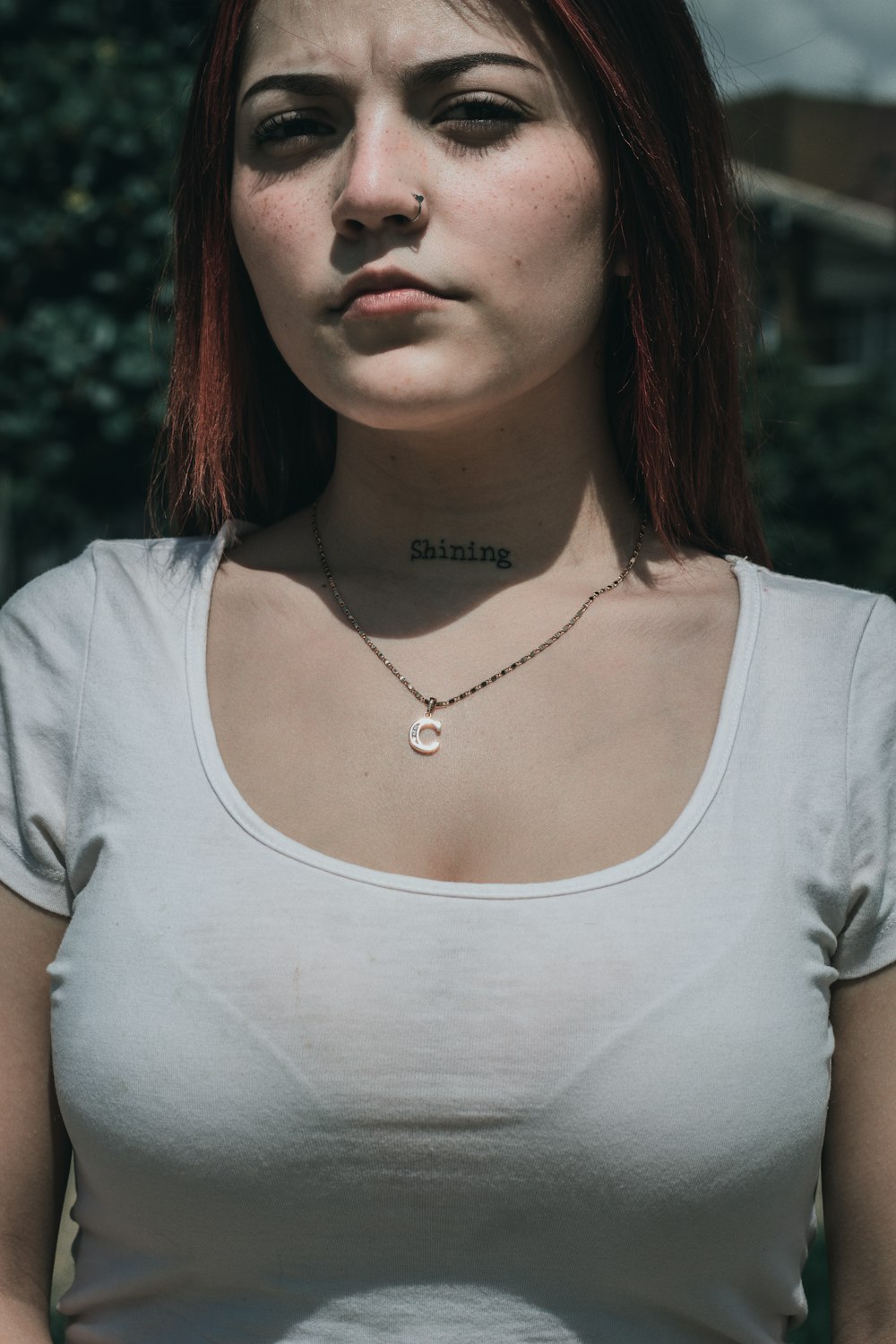 a woman with red hair wearing a white shirt