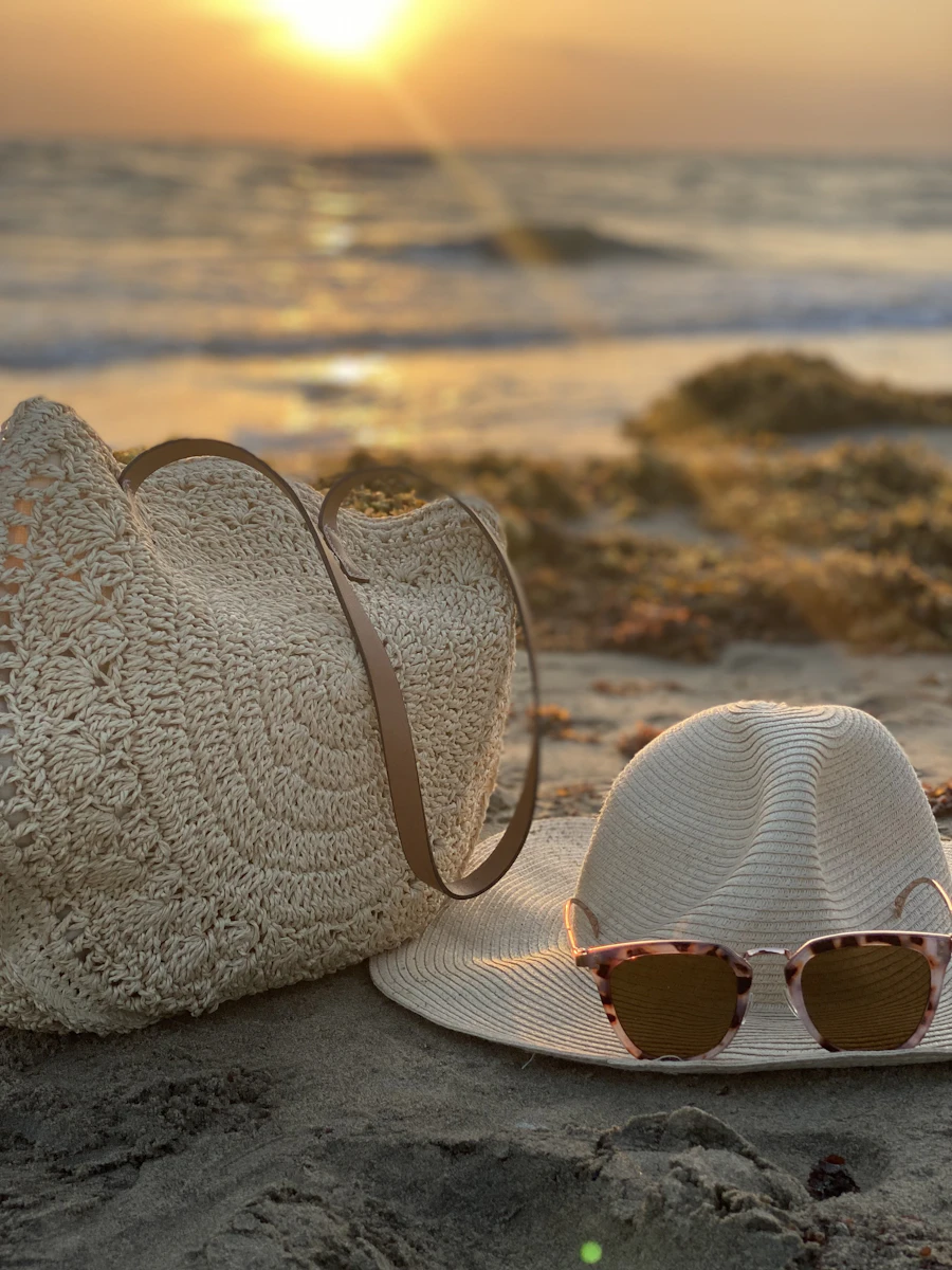 Straw bag and summer accessories on a beach