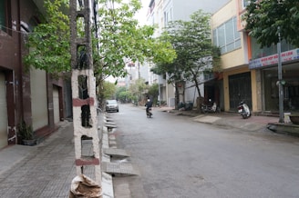 A rider enjoying a battcycles concept bike on a quiet city street with warm, off-white buildings in the background.