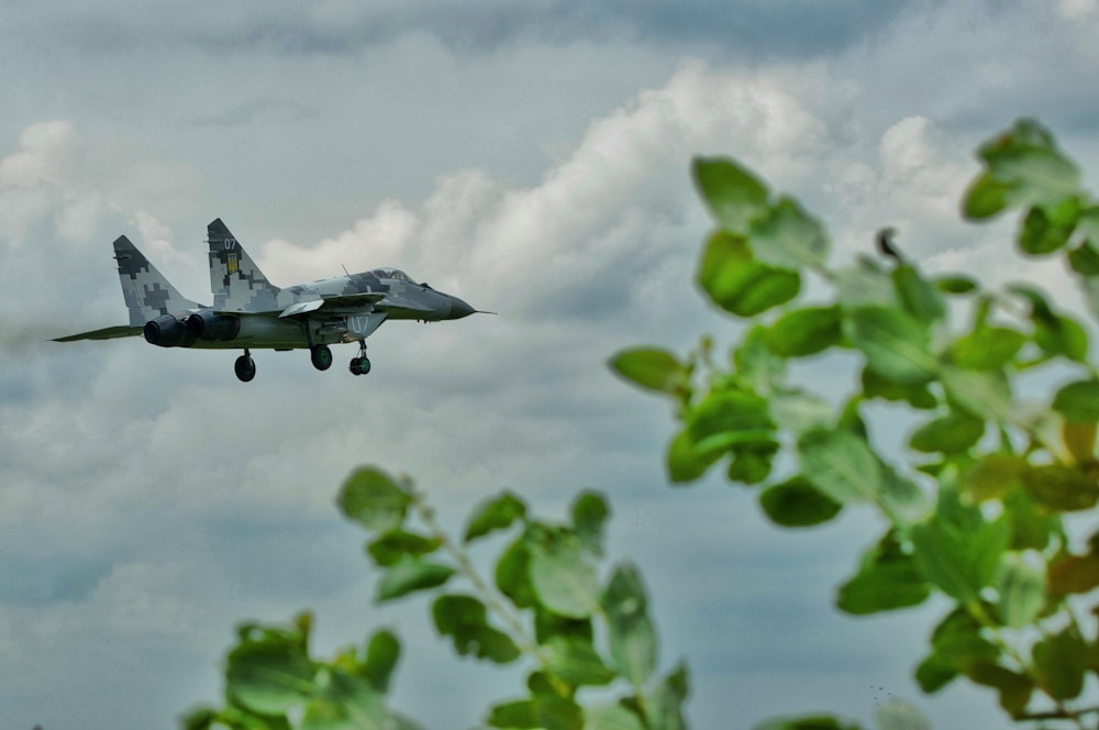 a fighter jet flying through a cloudy sky