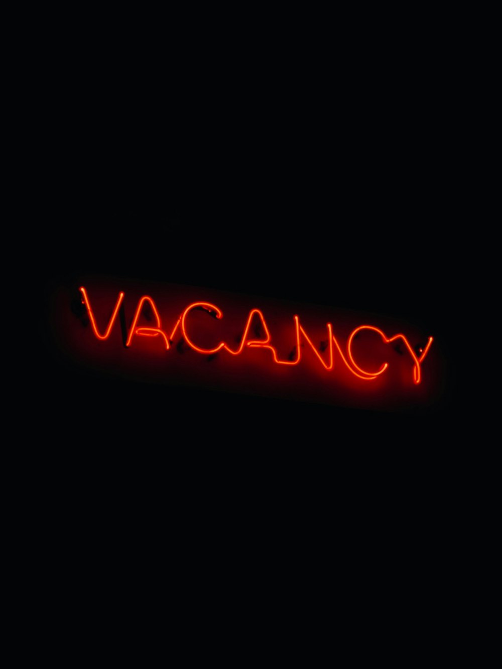a red neon sign that reads vacancy
