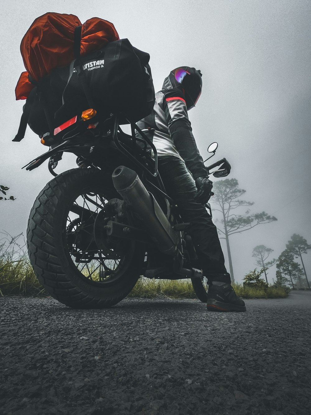 eine Person auf einem Motorrad mit einem Rucksack auf dem Rücken